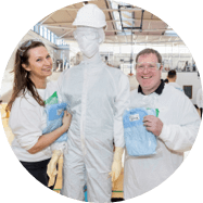 Two Regeneron employees smiling and posing next to a mannequin.